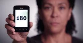 Mulher mostrando celular com o número 180, o disque denúncia para violência contra a mulher